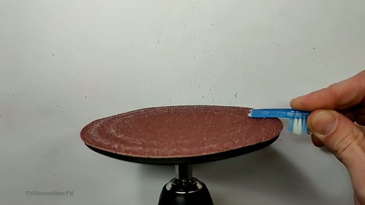 Sanding toothbrush bristles and base on sanding disc