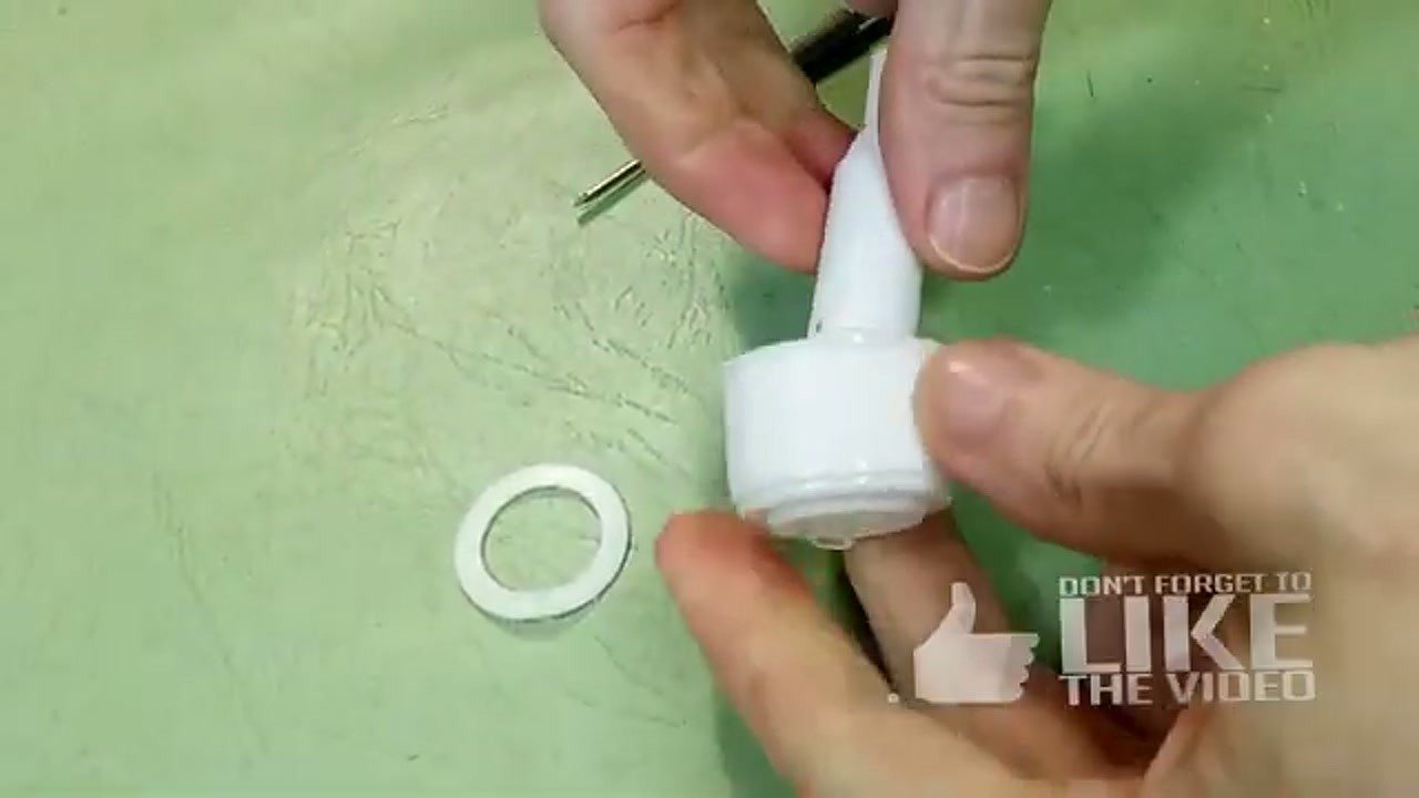 Attaching a white washer to the dispenser base