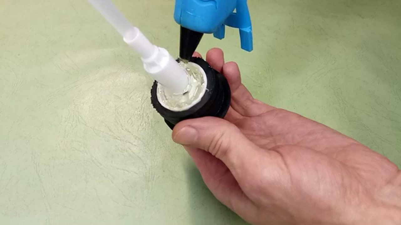 Applying hot glue to the bottle cap seal