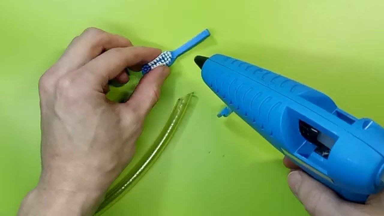 Applying hot glue to the toothbrush attachment
