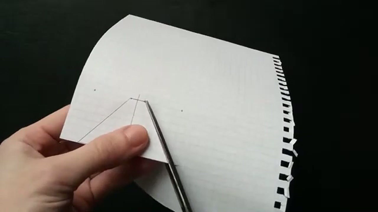 Cutting the paper template with scissors for the hologram projector