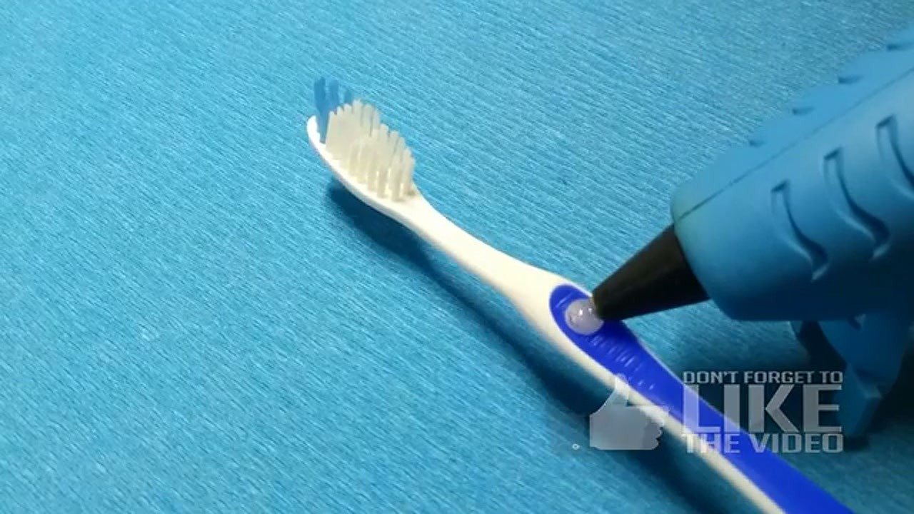 Applying hot melt adhesive to the toothbrush head