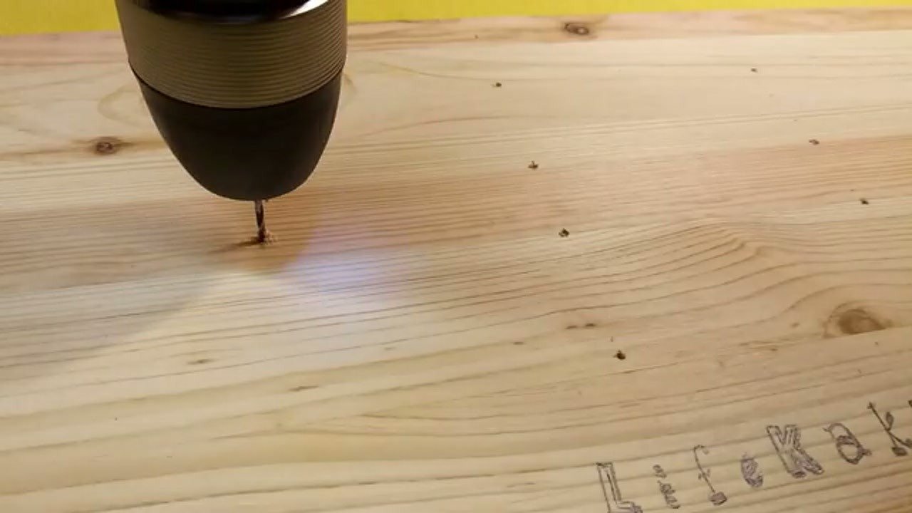 Drilling pilot holes into the wooden board