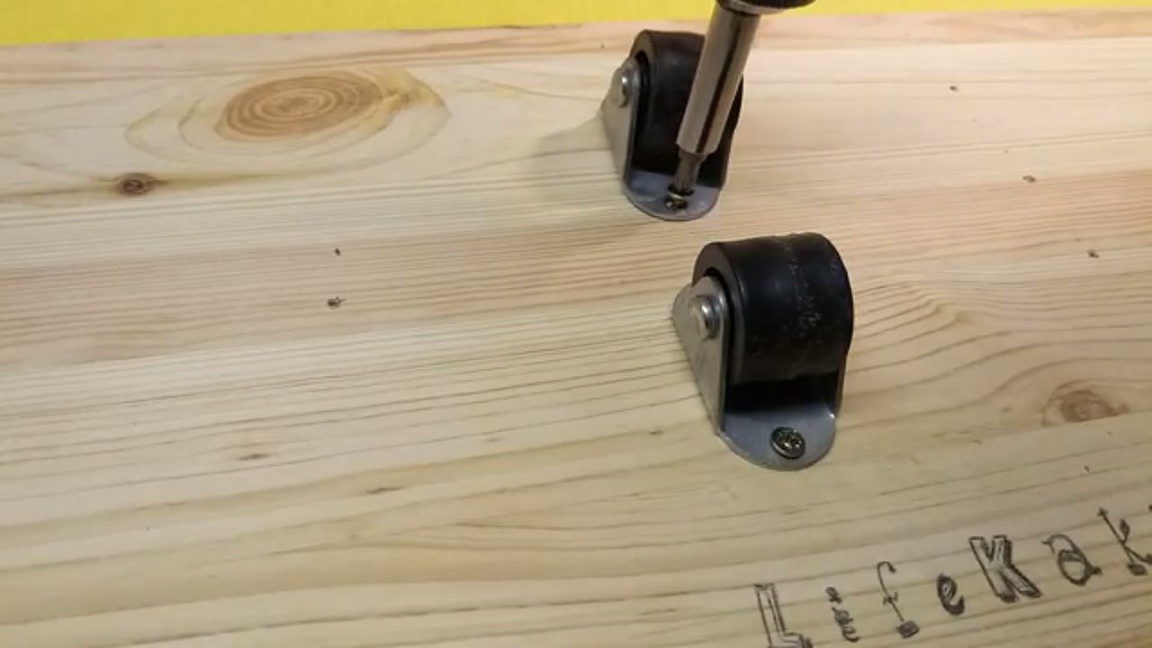 Screwing small rollers onto the wooden base