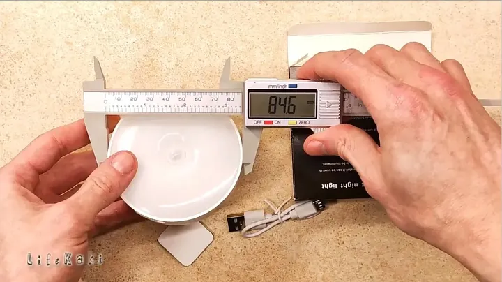 Measuring the assembled night light with calipers