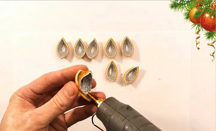 Applying hot glue to inner folds of craft ornament