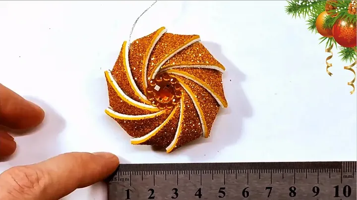 Measuring completed golden foam ornament with steel ruler