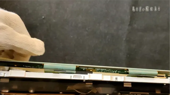Hands reassembling components during TV assembly